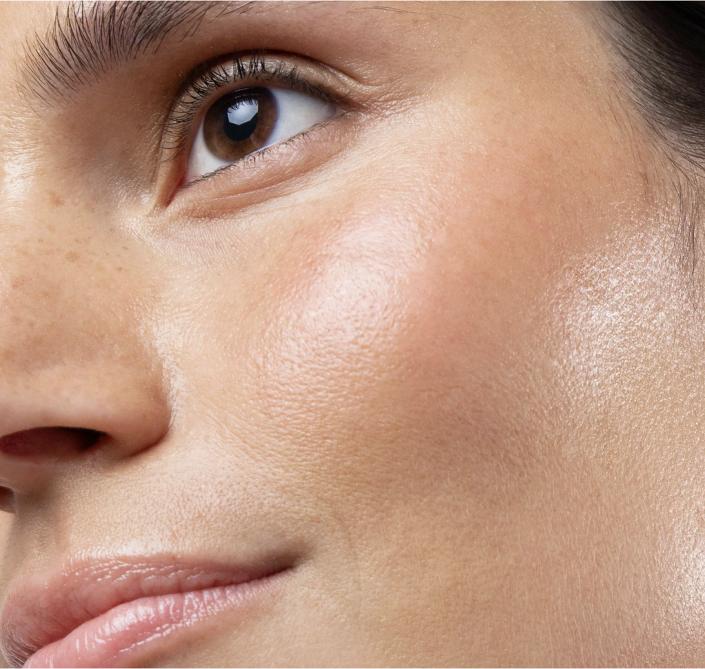Cette image est un gros plan sur le visage d’une femme, mettant en avant une peau lumineuse, hydratée et en bonne santé.